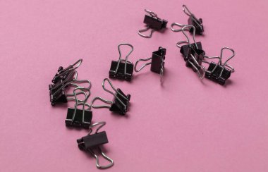 Pembe arka planda bir sürü ataç var. Minimalist ofis kavramı