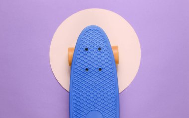 Sarı pastel daireli mor arka planda bir kruvazör tahtası. Gençlik hipster konsepti. Yaz eğlencesi. Üst görünüm