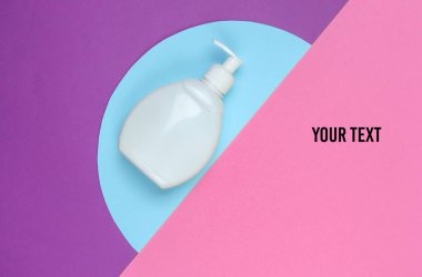 Renkli kağıt arka planda şampuan şişesi. Üst Manzara. Minimalist güzellik konsepti. Boşluğu kopyala