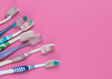 Pembe arka planda eski kullanılmış diş fırçaları. Diş bakımı konsepti. Üst Manzara. Boşluğu kopyala