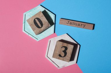 Ahşap blok takvimine göre tarih Ocak 03, pembe mavi arka plan. Üst görünüm