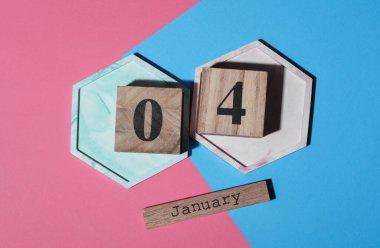 Ahşap blok takvimine göre tarih Ocak 04, pembe mavi arka plan. Üst görünüm