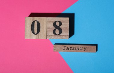 Ahşap blok takvimine göre tarih 8 Ocak, pembe mavi arka plan. Üst görünüm