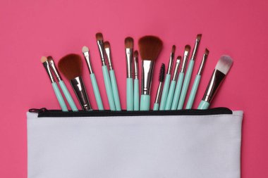 Pembe arka planda makyaj fırçası olan beyaz kumaş kozmetik çanta. Tasarım için model