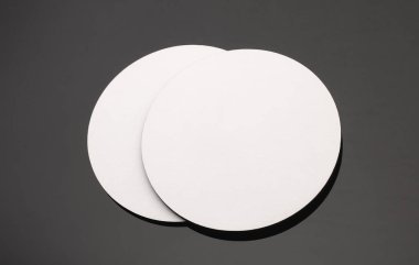 Siyah arka planda beyaz yuvarlak bardak altlıkları