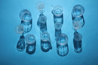 Mavi arka planda gölgeli bardaklar iç. Üst Manzara. Minimalizm, yaratıcı düzen