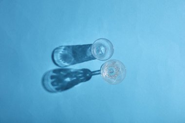 Mavi arka planda gölgeli bardaklar iç. Üst Manzara. Minimalizm, yaratıcı düzen