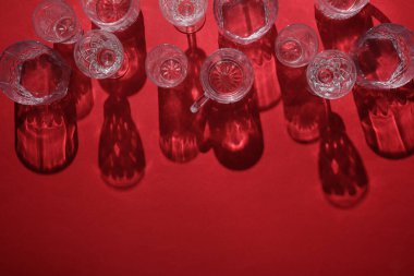 Kırmızı arka planda gölgesi olan bardaklar. Üst Manzara. Minimalizm, yaratıcı düzen