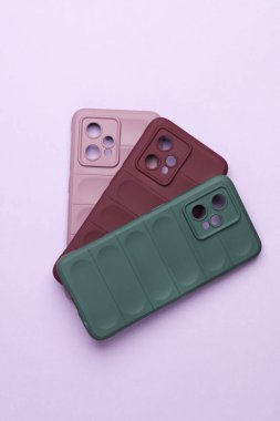 Mor arka planda akıllı telefon koruyucuları. Üst görünüm