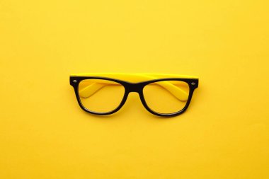 Sarı arka planda şık gözlükler. Üst görünüm