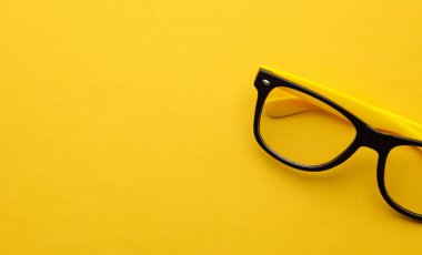 Sarı arka planda şık gözlükler. Üst görünüm