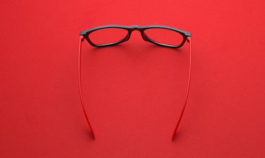 Kırmızı arka planda şık gözlükler. Üst görünüm