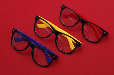 Kırmızı arka planda şık gözlükler. Üst görünüm