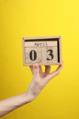 Tahta blok takvimi ve sarı arka planda tarih Nisan 03