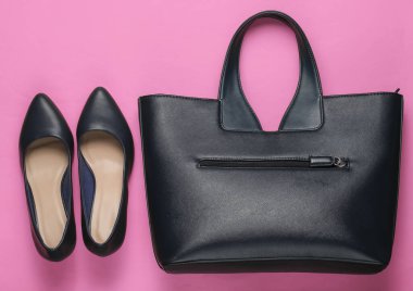 Klasik yüksek topuklu ayakkabılar, pembe arka planda deri çanta. Minimalizm moda kavramı. Üst görünüm