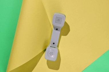 Üç Retro telefon ahizesi neon renkli kağıt arka planda. Popüler kültür. 80 'ler. Minimalist moda çekimi. Üst görünüm