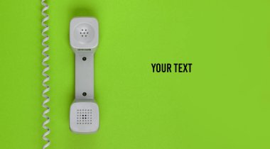 Yeşil arka planda kablolu cep telefonuna mesajınız için yer açın. Merkezi ara. Yardım hattı. Üst görünüm