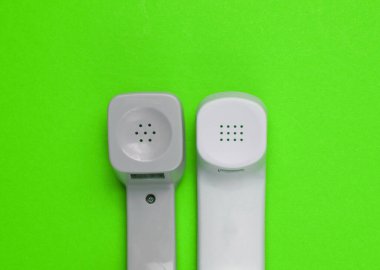 Yeşil arka planda iki eski telefon. Minimalizm. Üst görünüm