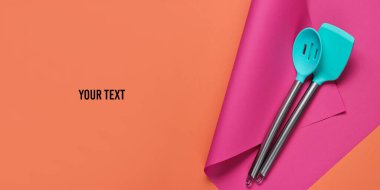 Renkli bir kağıtta mutfak araçları ve metin için boşluk. Minimalist yemek pişirme, hayat devam ediyor. Pastel renk eğilimi