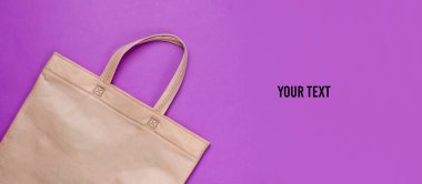 Mor arka planda eko torba, metin için yer var. Üst Manzara. Ekolojik minimalist kavram