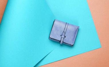 Deri cüzdan sarılı kağıt arkaplanda. Renkli trend, minimalist moda natürmort hayat. Üst görünüm