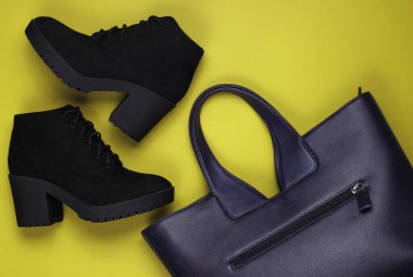 Deri çanta ve sarı kağıtta çizmeler. Minimalist moda hala hayattadır. Düz yatıyordu. Üst görünüm