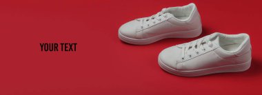 Kırmızı arka planda şık beyaz ayakkabılar. Stüdyo çekimi. Boşluğu kopyala