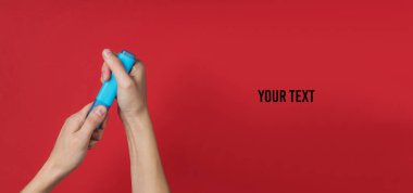 Kadın el, kırmızı arka planda mavi keçeli kalem tutuyor. Metnin için yer var. Üst görünüm
