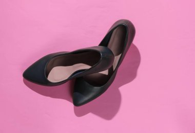 Pembe kağıttan arka planda klasik kadın topuklu ayakkabıları. Şık ayakkabılar. Stüdyo çekimi. Minimalist moda natürmort.