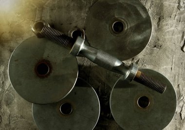 Gri beton arka planda eski parçalanmış halterler.