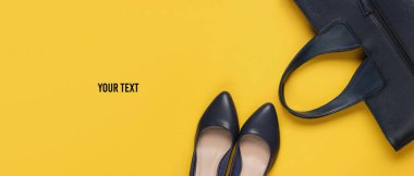 Klasik yüksek topuklu ayakkabılar, sarı arka planda deri çanta ve mesajın için yer. Minimalizm moda kavramı. Üst görünüm