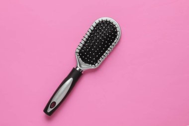 Pembe arka planda şık bir saç fırçası. Kadın Saç Bakımı Aksesuarları.