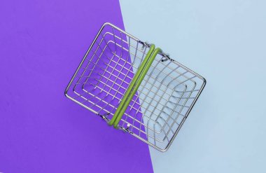 Mor mavi arka planda mini alışveriş sepeti. Üst görünüm