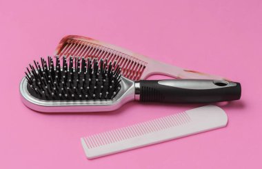 Pembe arka planda taraklar. Güzellik minimalist konsepti. Saç bakımı.