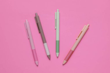 Pembe arka planda bir sürü renkli kalem var..