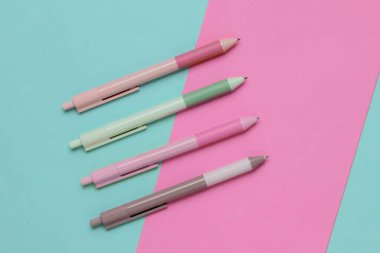 Pembe mavi arkaplanda bir sürü renkli kalem var..