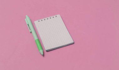 Pembe arka planda defter yakın plan pembe kalem. Pastel renk eğilimi