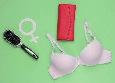 Yeşil arka planda sütyen ve kadın aksesuarları. Kadın giysisinin yukarıdan görünüşü. Moda kadın kıyafetleri. Düz yatış, üst görünüm.