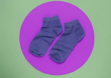 Yeşil arka planda kırmızı çoraplar ve ortasında pembe daireler. Minimalist moda hala hayattadır. Üst görünüm