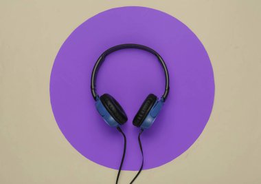 Yeşil arka planda, mor daireli modern kulaklıklar. Müzik aşığı kavramı.