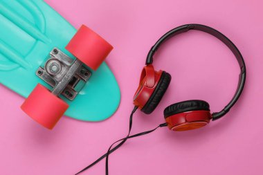 Kruvazör tahtası, pembe arka planda kulaklıklar. Yaz eğlencesi. Retro tarzı. 80 'ler. Üst görünüm