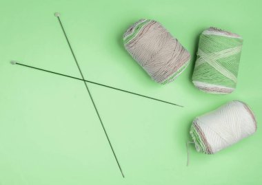 Yeşil arka planda örgü iğneleriyle yün ipliklerin derileri. Ev Kadınları Hobileri