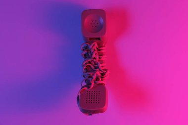 Eski moda bir cep telefonu. Kırmızı-mavi neon eğimli ışık. Retro dalga, popüler kültür. Üst görünüm