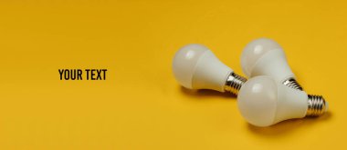 Sarı arkaplanda üç LED ampul ve metnin için yer