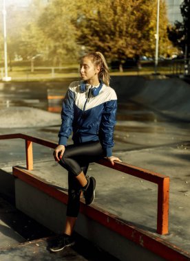 Spor giyimli genç bayan spor salonunda dinleniyor. Açık hava Egzersiz Konsepti