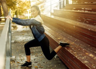 Sıska kadın bacak esnetme alıştırması yapıyor. Açık hava eğitimi. Sağlıklı yaşam tarzı kavramı