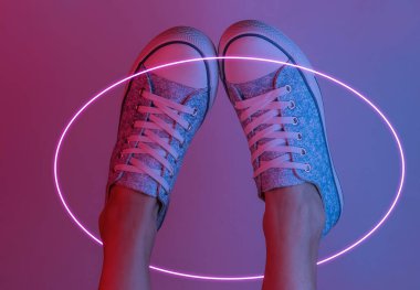 Spor ayakkabılı kadın ayakları. Yaratıcı pop sanatının pembe neon rengi. Moda eğilimli aydınlatma. Gece lambası