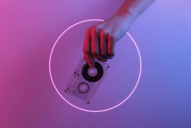 Retro dalga 80 'ler. El ele tutuşan ses kasedi. Yaratıcı pop sanatının pembe neon rengi. Moda eğilimli aydınlatma. Gece lambası