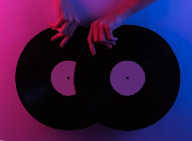 Retro dalga 80 'ler. Eller vinil plakları tutuyor. Yaratıcı pop sanatının pembe neon rengi. Moda eğilimli aydınlatma. Gece lambası