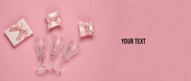 Retro tarzı kristal şarap kadehleri ve pembe arka planda hediye kutuları. Noel konsepti. Üst Manzara. Boşluğu kopyala